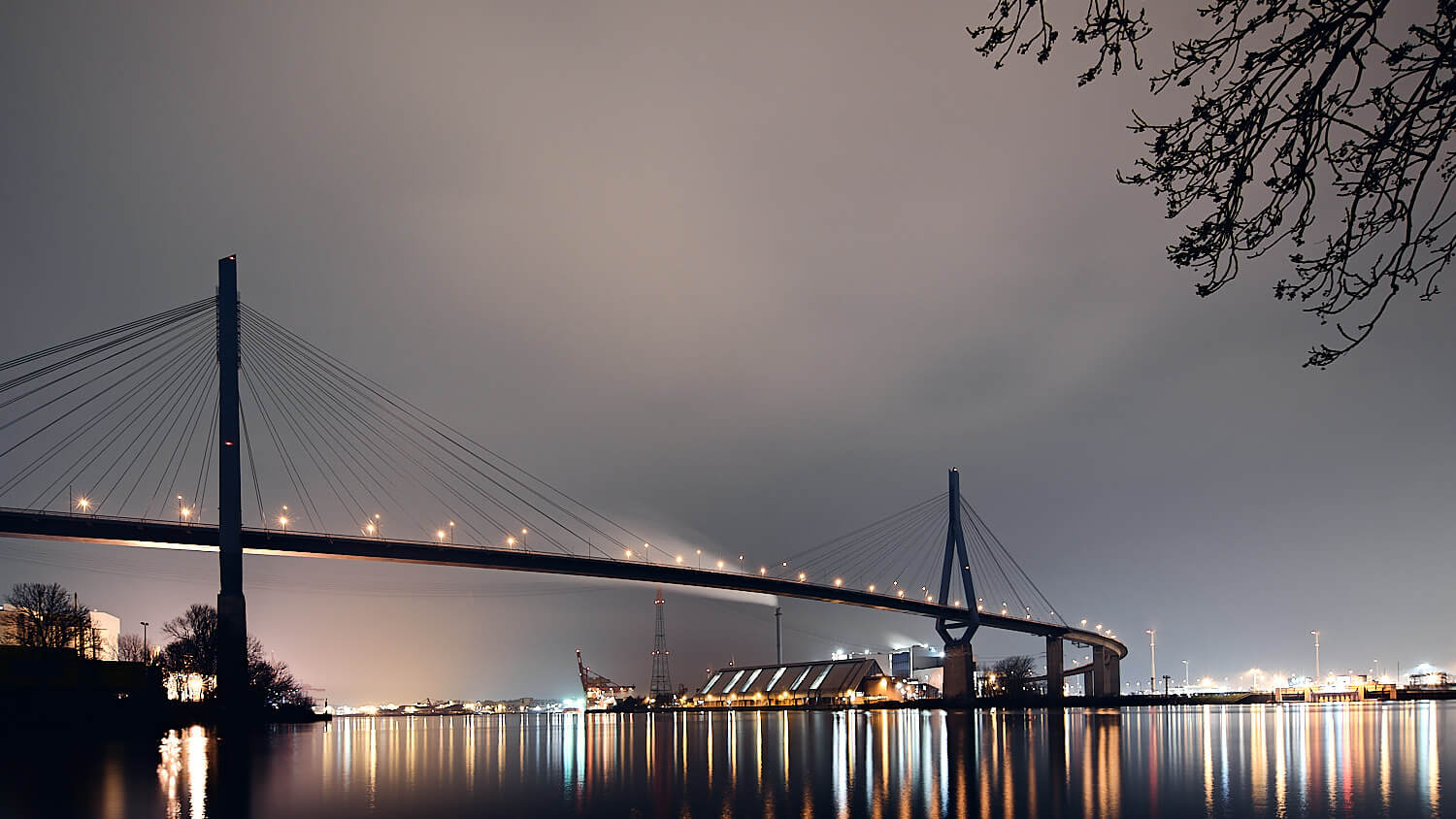 Die Köhlbrandbrücke ist eine imposante Stahlkonstruktion über der Elbe in Hamburg. Fertiggestellt 1974, dient sie als wichtige Verbindung für den Hafenverkehr. Mit einer Länge von etwa 3,5 Kilometern und über 50 Metern Höhe prägt sie die Hamburger Skyline und symbolisiert die Bedeutung des Hafens für die Stadt.